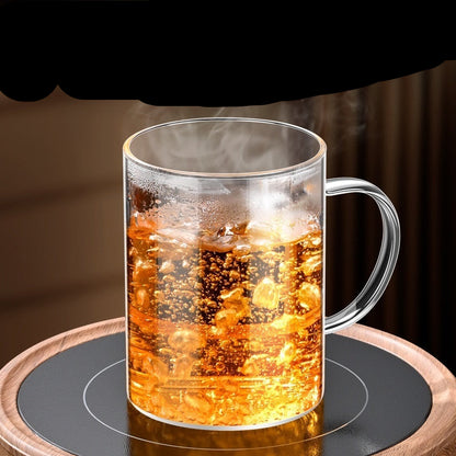 Clear glass mug with hot beverage on a wooden coaster, text about borosilicate glass properties.