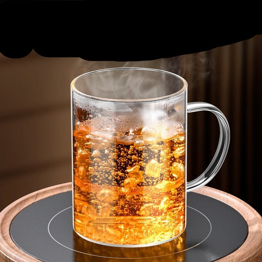 Clear glass mug with hot beverage on a wooden coaster, text about borosilicate glass properties.