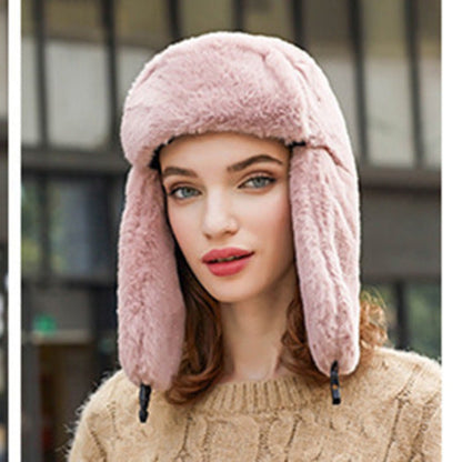 Woman wearing a pink fur-trimmed hat with a blurred background