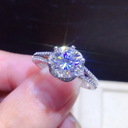 Diamond ring held in a hand with a dark background