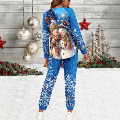 Person wearing a blue Christmas-themed outfit with snowmen and snowflakes in front of a decorated Christmas background.