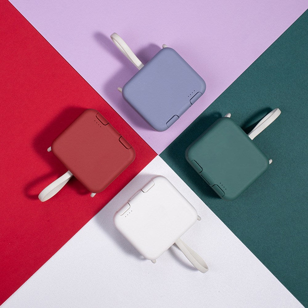 Five portable chargers in red, blue, green, and white on a colorful geometric background