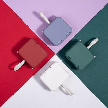 Five portable chargers in red, blue, green, and white on a colorful geometric background