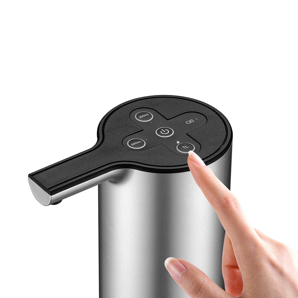 Hand pressing a button on a stainless steel water dispenser with text about volume options.