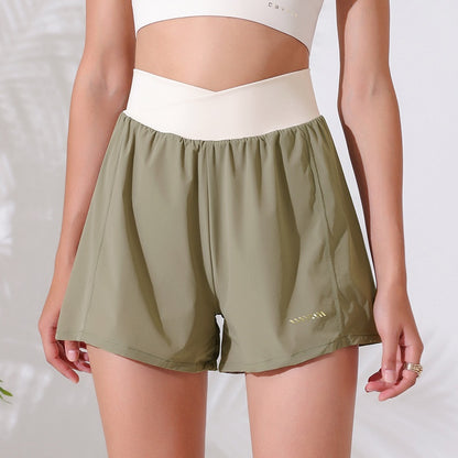 Person wearing green athletic shorts and a white top on a light background