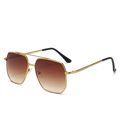 Gold-framed sunglasses with brown gradient lenses on a white background