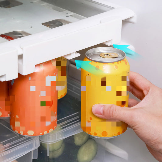 Hand holding a can of orange juice with a colorful label inside an open refrigerator.