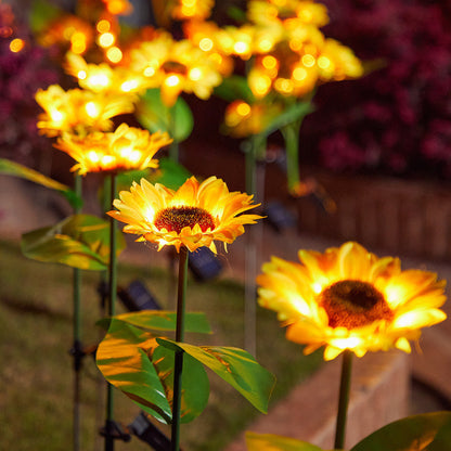 Solar-powered sunflower lights in a garden setting with blurred flowers in the background.