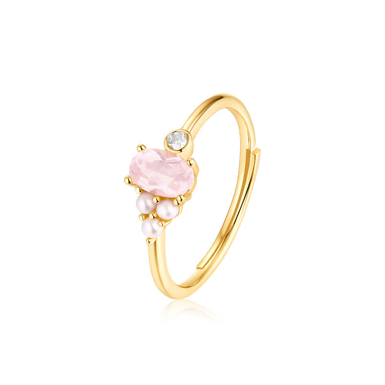 Gold ring with pink gemstone and pearls on a white background