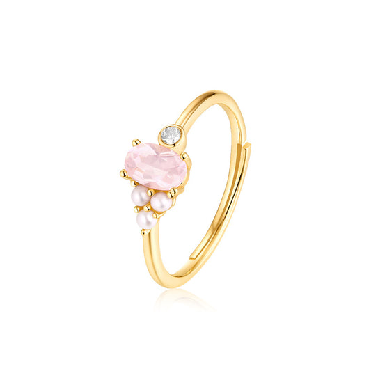 Gold ring with pink gemstone and pearls on a white background