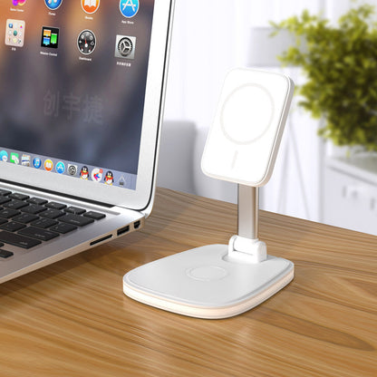 White desk lamp on a wooden surface next to a laptop