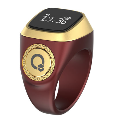 Gold and red smart ring with digital display on a white background