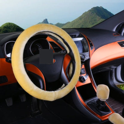 Car interior with a yellow steering wheel cover and gear shift cover against a mountainous background.