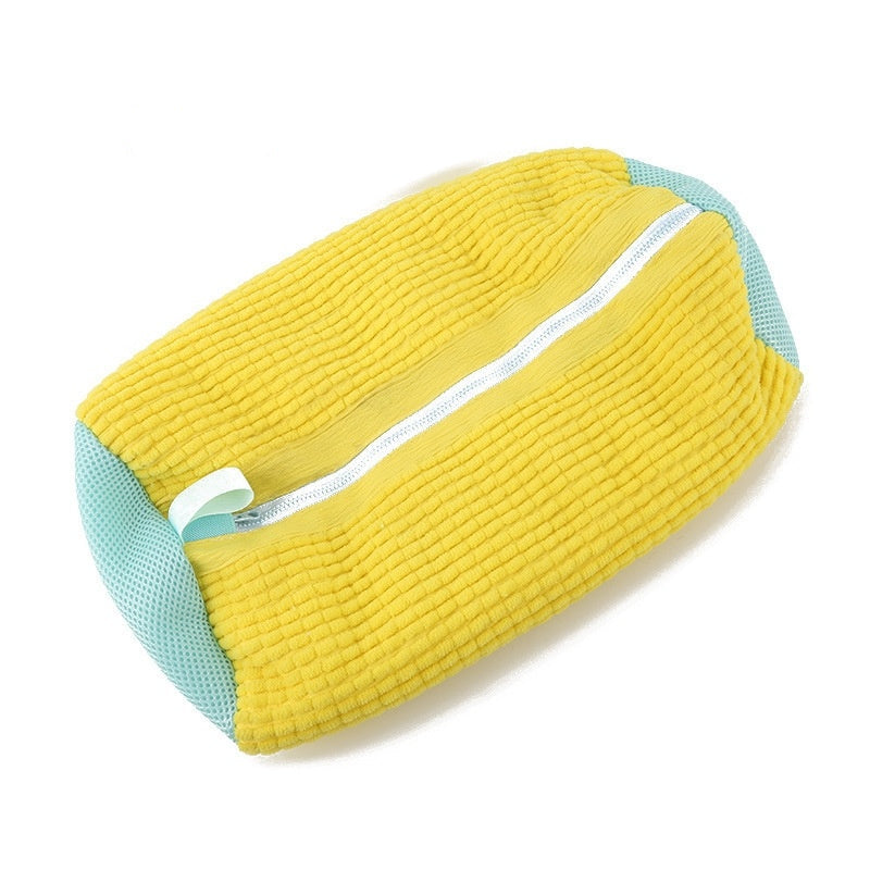 Yellow and teal pillow with a zipper on a white background