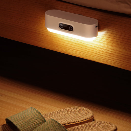 White LED wall light on a wooden wall with a warm glow.