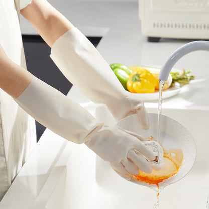 Person washing dishes with gloves on in a kitchen setting