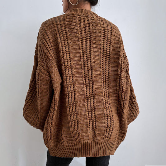 Brown knitted sweater worn by a person against a plain background
