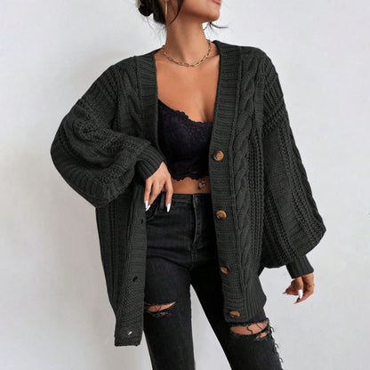 Person wearing a black cardigan over a black bralette and jeans.