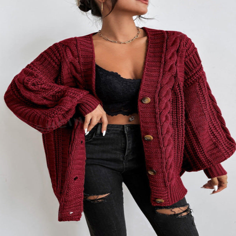 A woman wearing a wine red V-neck knitted cardigan with lantern sleeves, paired with a black top and black ripped jeans. She is also carrying a black bag and wearing black shoes.