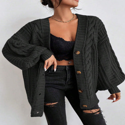 A woman wearing a wine red V-neck knitted cardigan with lantern sleeves, paired with a black top and black ripped jeans. She is also carrying a black bag and wearing black shoes.