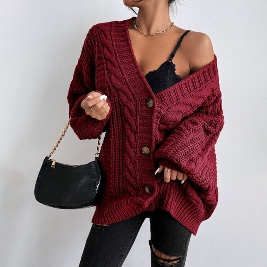 A woman wearing a wine red V-neck knitted cardigan with lantern sleeves, paired with a black top and black ripped jeans. She is also carrying a black bag and wearing black shoes.