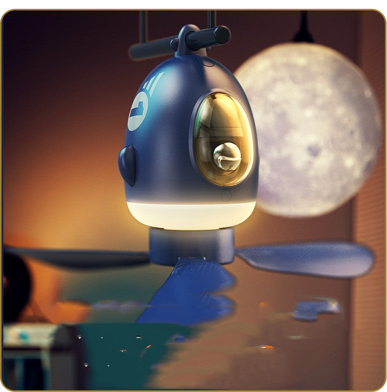 Blue robot-like lamp with a gold lens on a dark background