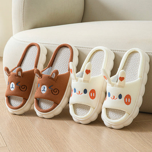 Pair of brown animal-themed slippers and a pair of white slippers with cartoon faces on a light wooden floor.
