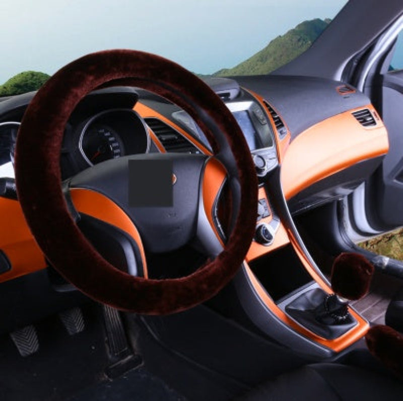 Car interior with a brown steering wheel cover and orange dashboard.