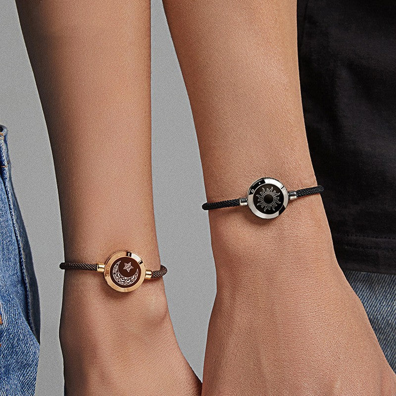 Two wrists wearing elegant bracelets with circular designs on a neutral background