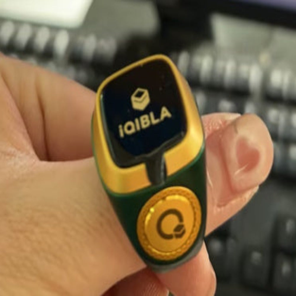 IQIBLA device held in a hand with a keyboard in the background