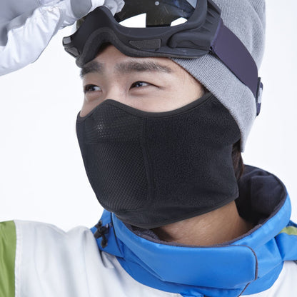 Person wearing a black face mask, goggles, and winter clothing on a white background