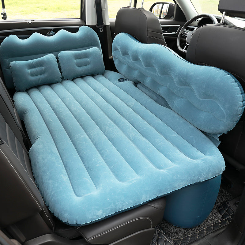 Inflatable car mattress set up in a vehicle with two pillows.