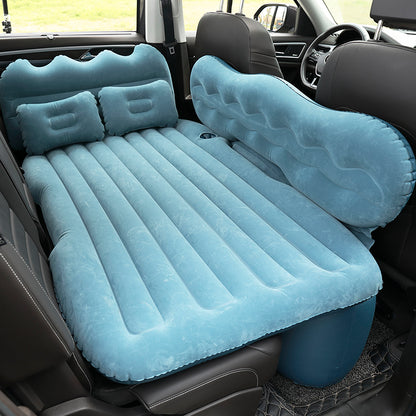 Inflatable car mattress set up in a vehicle with two pillows.