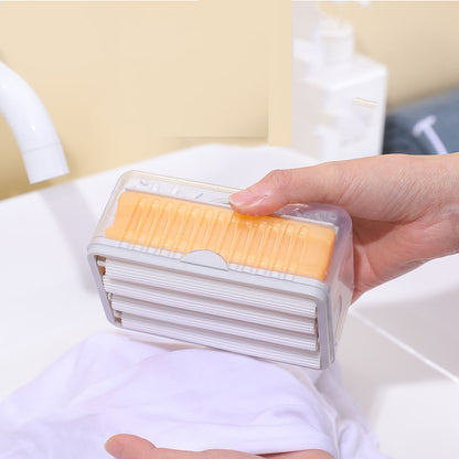 Hand holding a transparent container with yellow and white items against a neutral background