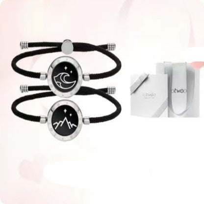 Two black Milan rope silver bracelets with a boutique gift box on a light pink background.