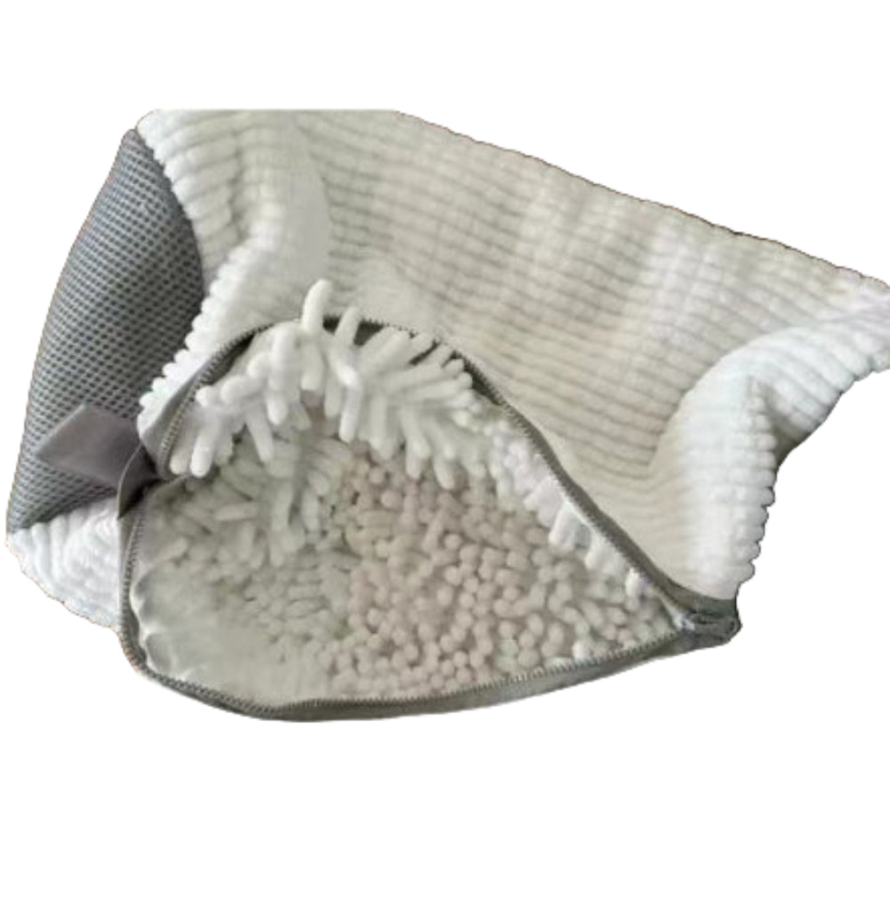 A shoe being washed in a yellow laundry bag with a grey zipper, placed in a washing machine.