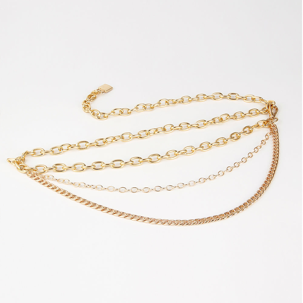 Gold chain necklace on a light gray background