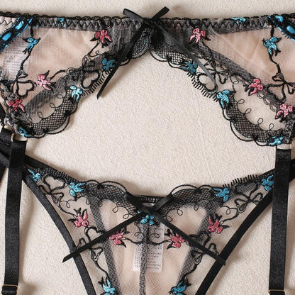 Black lace lingerie set with floral embroidery on a light background