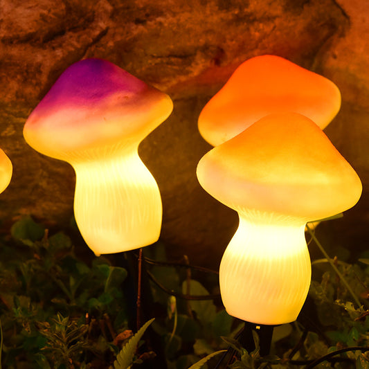 Two mushroom-shaped lights glowing in a natural setting with rocks and plants.