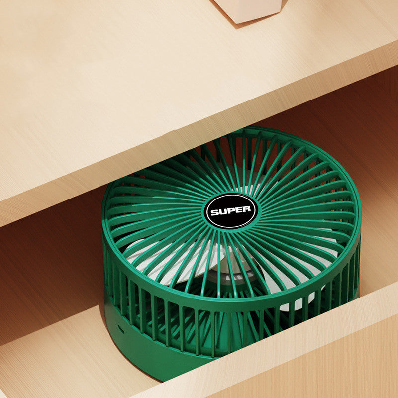 Green portable fan on a wooden surface
