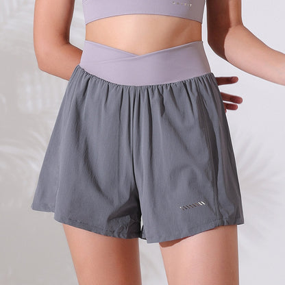 Person wearing gray athletic shorts and a matching top on a plain background