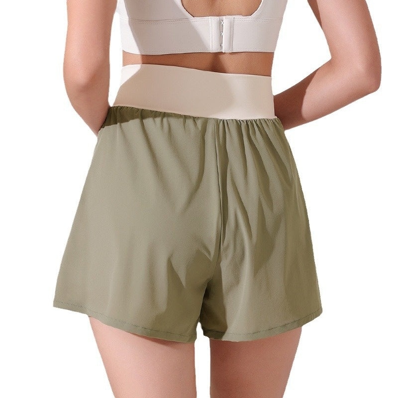 Person wearing olive green shorts and a white sports bra on a white background