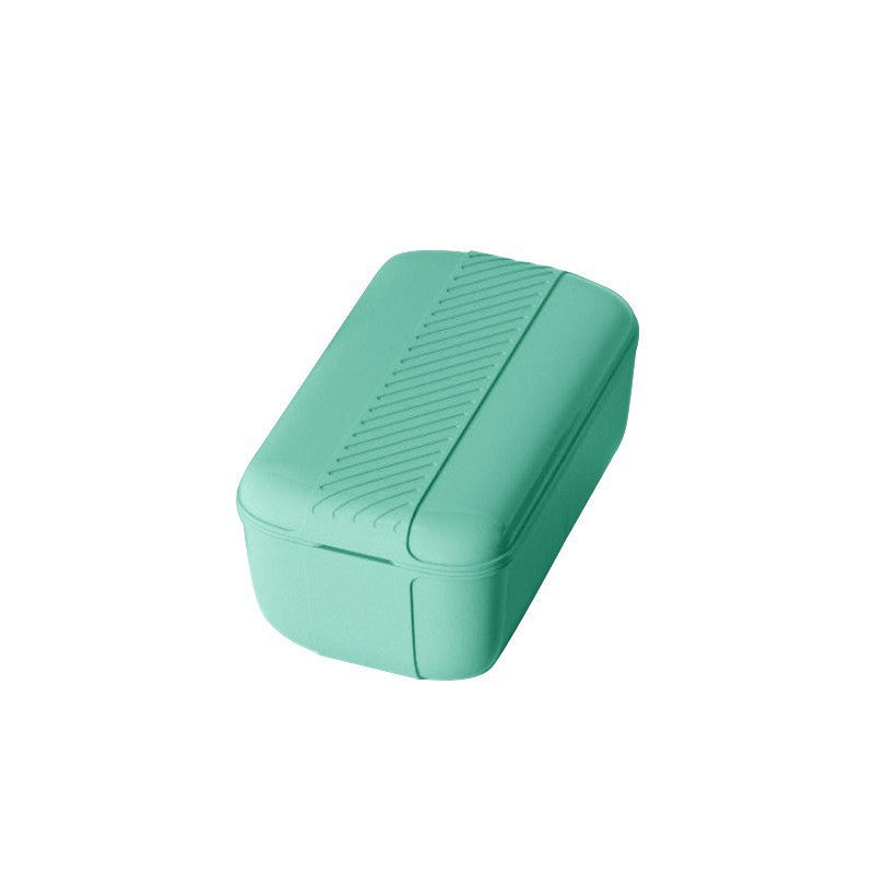Green rectangular container with textured lid on a white background