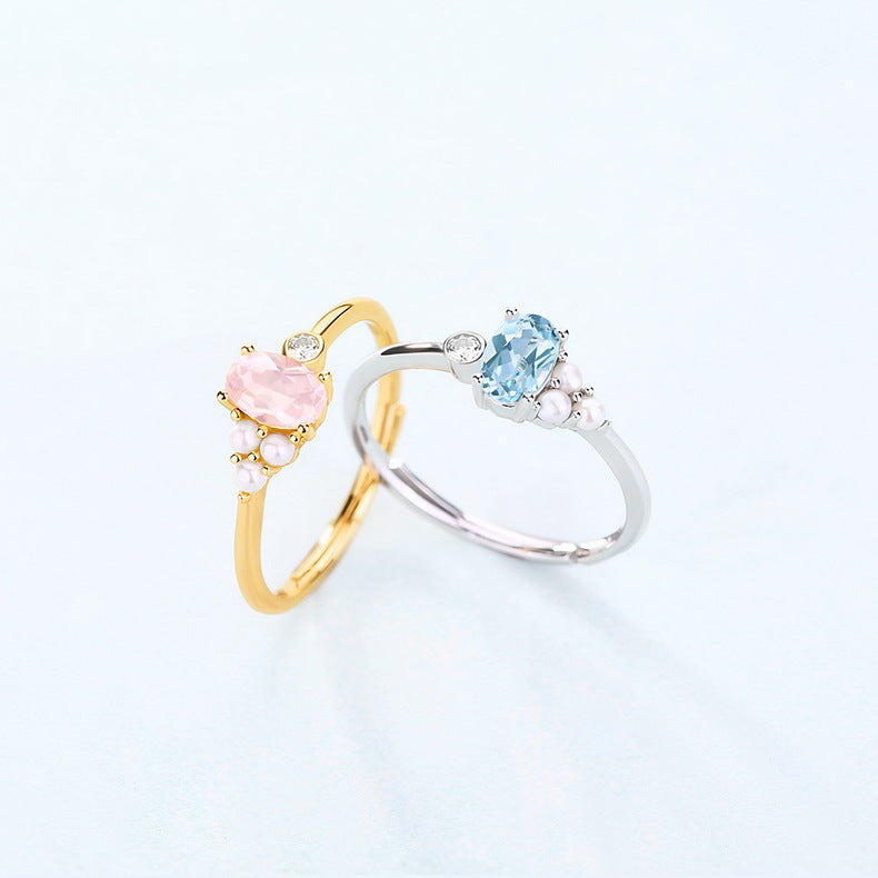 Two rings, one gold and one silver, each with a central gemstone on a light background