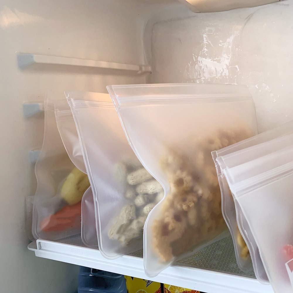 Clear plastic food storage bags of various sizes containing food items, placed in a refrigerator.