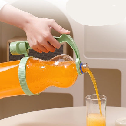 Hand pouring orange juice from a bottle with a green handle into a glass.