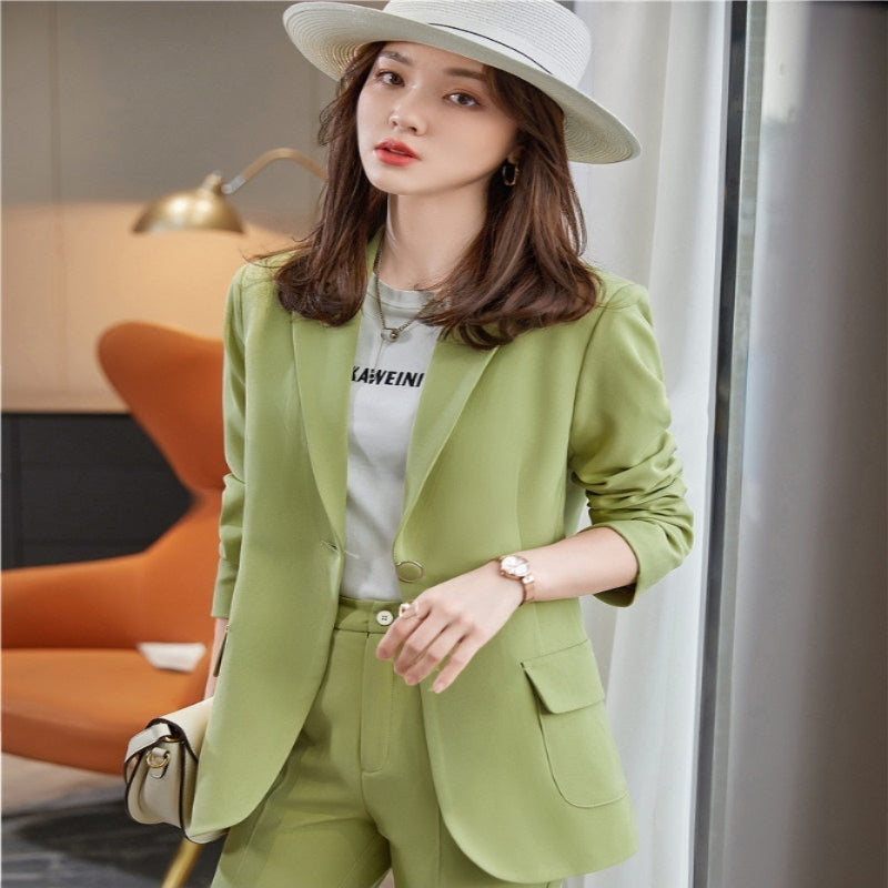 Woman wearing a green blazer coat in an indoor setting