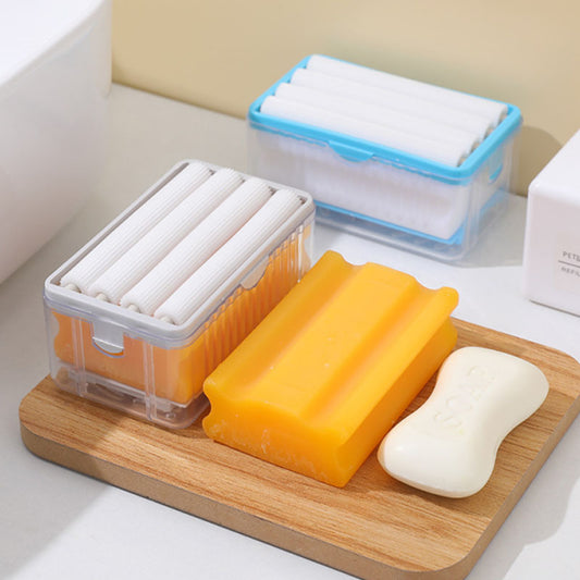 Bar of soap and two containers with rolled-up cloths on a wooden board.