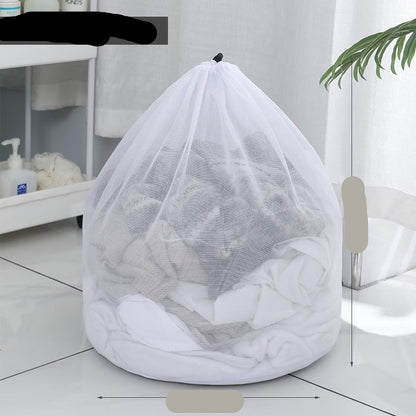 Two white mesh laundry bags filled with laundry standing in front of a washing machine with a person partially visible in the background.