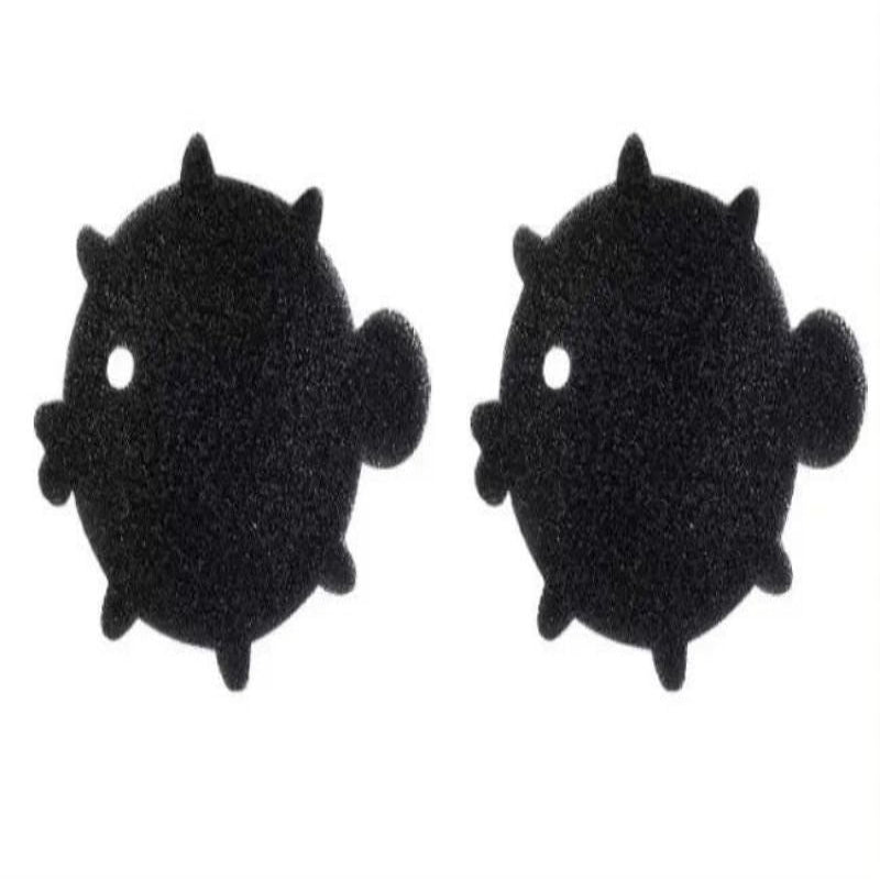 A black sponge shaped like a bear is shown being used to pick up pet hair from a beige surface, demonstrating its use as a cleaning tool.
